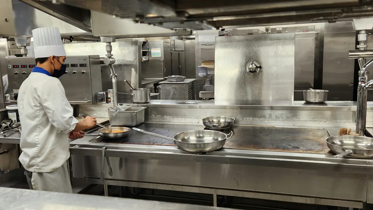 a chef cooking in a kitchen — professional food preparation environment