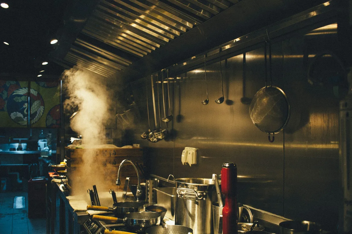 stainless steel cooking pots on stove — professional food preparation environment