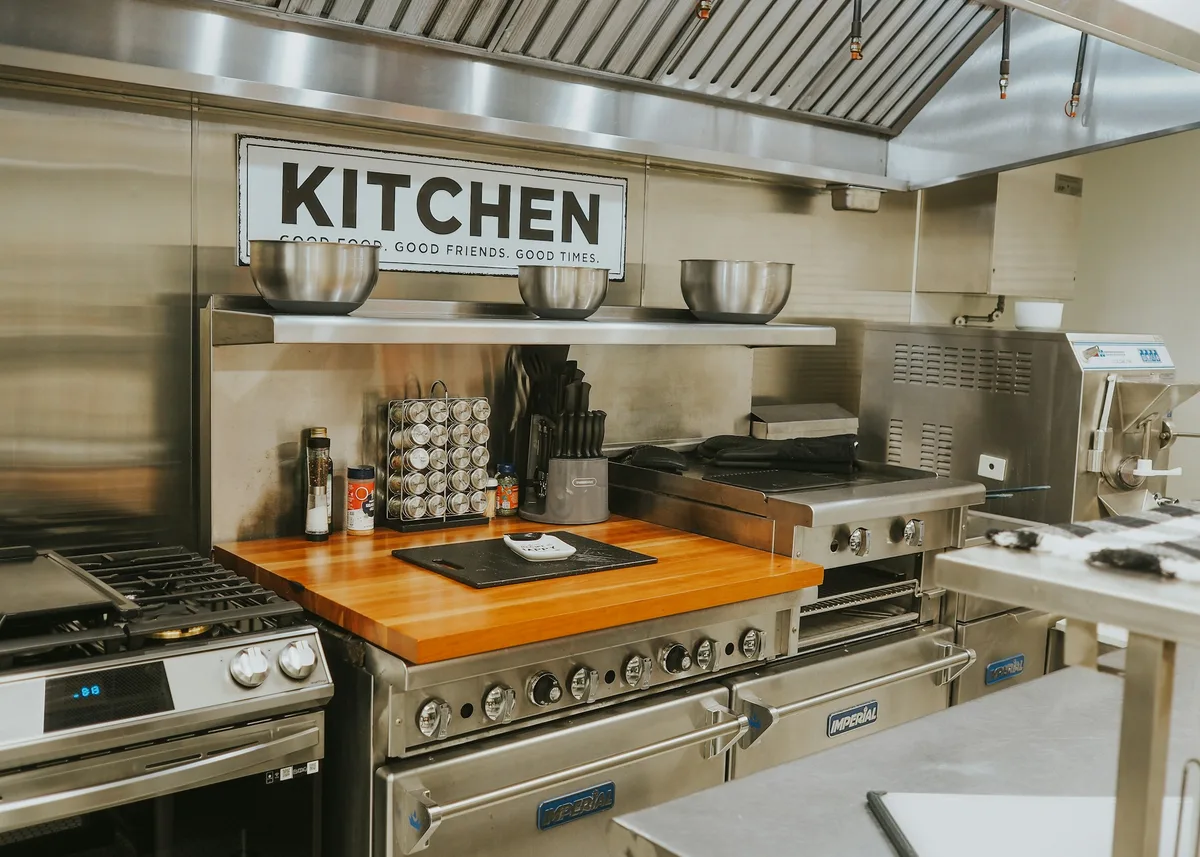 a kitchen with stainless steel appliances and a wooden counter — professional food preparation environment
